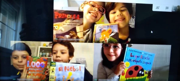 Alumnos mostrando sus libros a la cámara durante una clase virtual